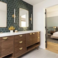 a bathroom with two mirrors, a sink and a large mirror on the wall above it