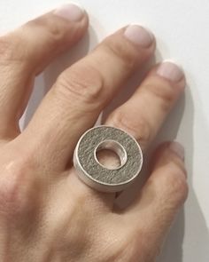 "This open round geometric ring is made of sterling silver with a circular bar inlaid with grey concrete. The surface of the ring has a rough matte finish. It's a ring which catches the eye and completes perfectly a rather minimalist outfit! As each piece is individually handcrafted, slight variations in the texture of the concrete are possible. This exquisite necklace  are also available in a matching with earrings  and necklace. www.etsy.com/shop/ArtisJewels?ref=seller-platform-mcnav&search_query=c1 DESCRIPTIONS and MEASUREMENTS: Materials: Sterling silver and concrete . Diameter: 2,2(cm) 0,86x(in)\" thickness 0,5 (cm) 0,19 (in\") SEE MORE CONCRETE JEWELRY HERE: www.etsy.com/shop/ArtisJewels?ref=seller-platform-mcnav§ion_id=36353295 Visit my Etsy shop, ArtisJewels, to see more rings and Minimalist Gray Sterling Silver Jewelry, Minimalist Gray Jewelry For Everyday, Gray Minimalist Jewelry For Everyday Wear, Gray Minimalist Jewelry For Everyday, Circular Bar, Concrete Ring, Concrete Jewelry, Geometric Ring, Minimalist Outfit