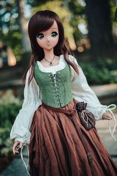 a doll with long hair wearing a dress and holding a handbag in her other hand