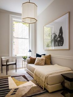 a living room filled with furniture and a painting hanging on the wall next to a window