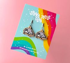 a pair of earrings on top of a card with the words, spin and drool club