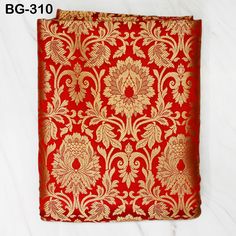 a red and gold brocaded cloth with an intricate design on the front side