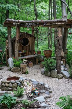 an outdoor play area in the woods surrounded by rocks and trees with lots of greenery