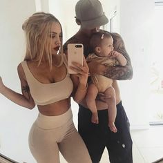 a man and woman taking a selfie with their baby