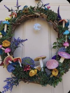 a wreath with flowers and mushrooms on it