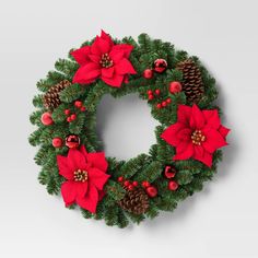 a christmas wreath with poinsettis and pine cones