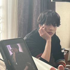 a person sitting at a desk with a laptop and cell phone in front of them