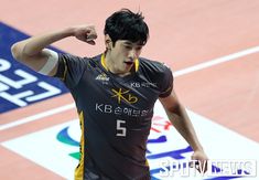 a man holding his fist up while standing on top of a basketball court