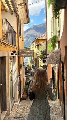 a woman is walking down an alley way