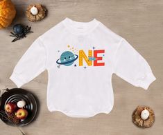 One Space Baby Romper Sweatshirt, First Birthday Baby Romper, Space Theme 1St Birthday Bodysuit, Bubble Romper, Baby Boy Clothes - Handmade - Ships from USA - Materials: 100% CPSIA Compliant and Ethically Made material Light fabric (5.0 oz/yd² (170 g/m Crafted with soft, breathable fabric, this romper ensures your baby stays comfortable through playtimes and nap times alike. Featuring charming designs suitable for all babies, our romper is as adorable as it is practical. Quick Sizing Tip Our rom White Long Sleeve Tops For First Birthday, Birthday Bodysuit, Nap Times, M Craft, Space Baby, Bubble Romper, Space Theme, Boy Clothes, Gender Neutral Baby