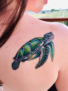 a woman with a green turtle tattoo on her shoulder