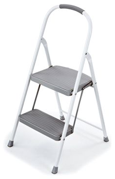 the two step stool is white and has grey steps on each side, with one foot up