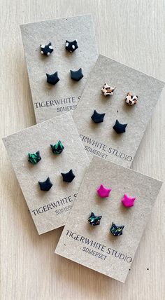 four pairs of earrings are displayed on top of a card with the words tigerwhite studio