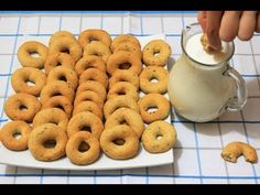 a plate full of doughnuts next to a glass of milk