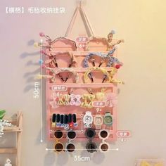 a pink wall mounted display case with various pairs of eyeglasses and accessories on it