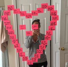 a woman taking a selfie in front of a mirror with sticky notes attached to it