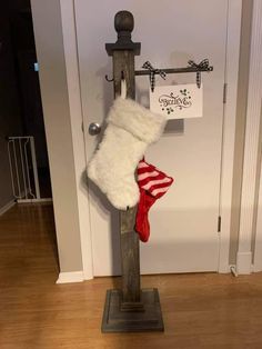 a christmas stocking hanging on a pole in front of a door with a sign