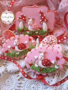 three decorated cookies sitting on top of a lace covered tablecloth next to each other