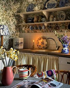 the kitchen is decorated with blue and white dishes, flowers in vases, and candles