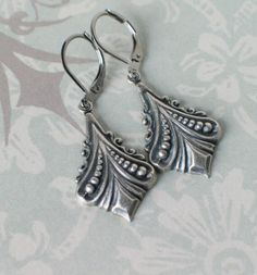 "These beautiful Art Deco silver plated brass earrings are reminiscent of Downton Abbey and designs from the 1920s and 1930s. They hang from stainless steel leverback earwires and hang 1 3/4\" long. Comes in a lovely gift box with ribbon." Antique Silver Vintage Dangle Jewelry, Vintage Antique Silver Dangle Jewelry, Vintage Antique Silver Dangle Earrings, Vintage Sterling Silver Jewelry For Vintage Events, Sterling Silver Vintage Jewelry For Vintage Events, Handmade Antique Silver Vintage Earrings, Sterling Silver Vintage Jewelry For Events, Handmade Vintage Antique Silver Earrings, Handmade Vintage Sterling Silver Earrings