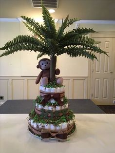 a cake made to look like a tree with a monkey on top and diapers around it