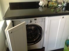 a white washer sitting inside of a kitchen next to a dryer and sink