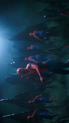 many spider - man suits are lined up in a row, with one being suspended upside down