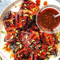 chicken wings with sauce and green onions on a plate