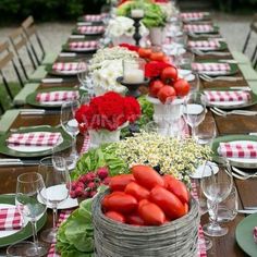 a long table with red and white checkered cloths, green place mats and plates