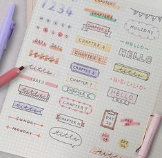 a notebook with some stickers on it next to a pink pen and two pens