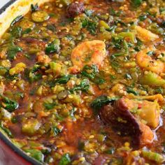 a pot filled with shrimp and vegetables on top of a table