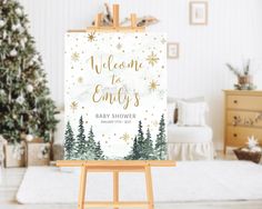 an easel with a baby shower sign on it in front of a christmas tree