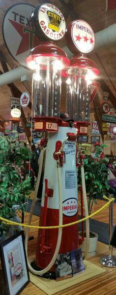 a red and white machine sitting on top of a wooden table next to a potted plant