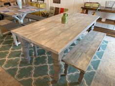 a wooden table and bench in a room with blue rug on the floor next to it