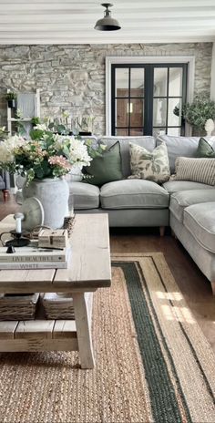 a living room filled with lots of furniture and flowers on top of a wooden table