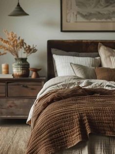 a bed sitting in a bedroom next to a dresser with drawers and pictures on the wall