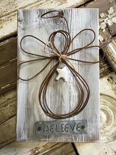 an image of a wooden plaque with a bow on it and the words believe spelled by susan stewart