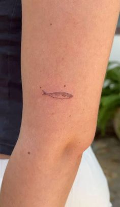 a person with a small tattoo on their leg that has a fish on it's side