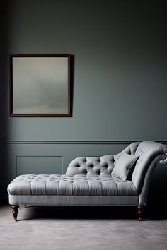 a gray chaise lounger sitting in front of a painting