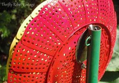 a close up of a metal object with holes on it's side and a green handle