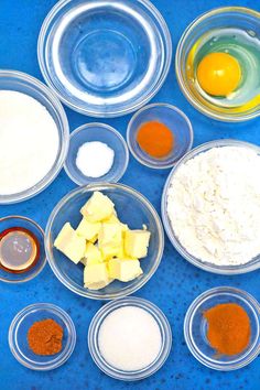 the ingredients to make an egg muffin are arranged in separate bowls on a blue surface