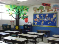 an empty classroom with desks and trees on the wall