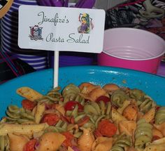 a blue bowl filled with pasta and vegetables next to a sign that says jalapeno's gusta salad