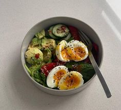 a salad with hard boiled eggs and spinach in it on a white counter top