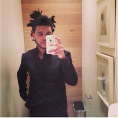 a man taking a selfie in front of a mirror with dreadlocks on