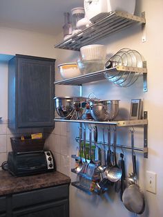 a kitchen with pots and pans hanging on the wall next to a stove top oven