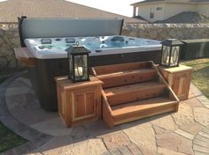 a hot tub sitting on top of a stone patio