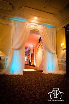 an image of a room with curtains and lights on the walls, in front of a doorway