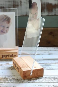 a wooden block with a glass holder holding a baby's photo and an acrylic stand