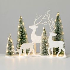 a white christmas scene with deer and trees